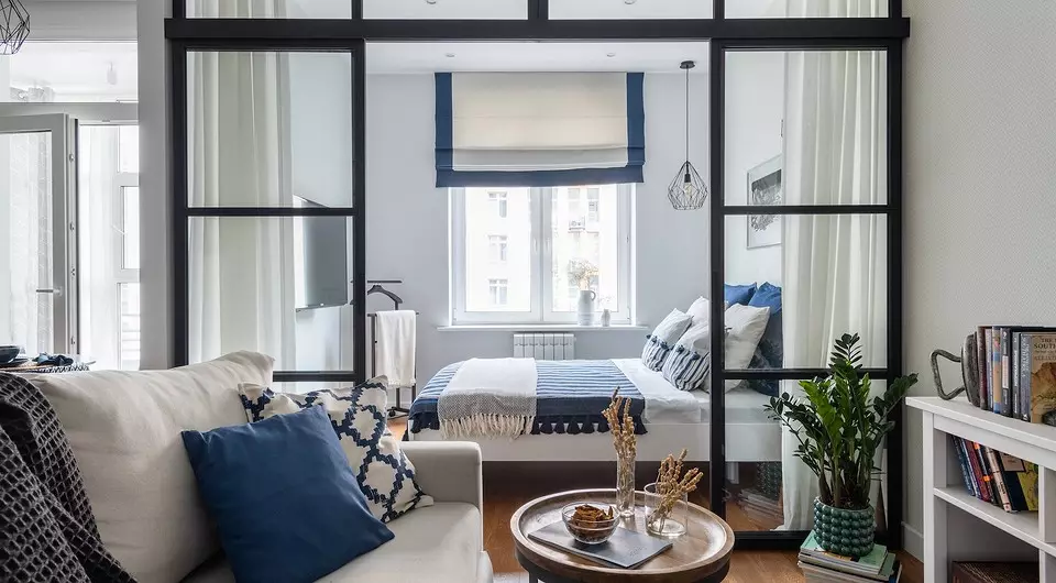 Pequeño apartamento de estilo escandinavo con paredes blancas y acentos azules.