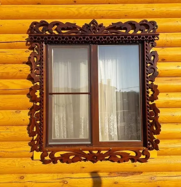 Geschnitzte Platbands an den Fenstern in einem Holzhaus: Muttersnitm und installieren Sie es selbst 9481_30