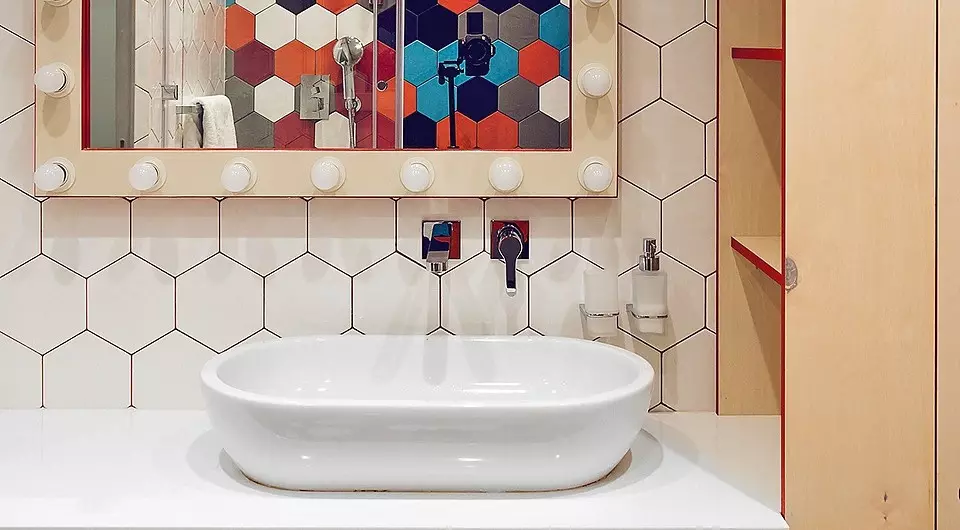 Veselá interiérová kúpeľňa s viacfarebnými dlažbami a červenou mastou